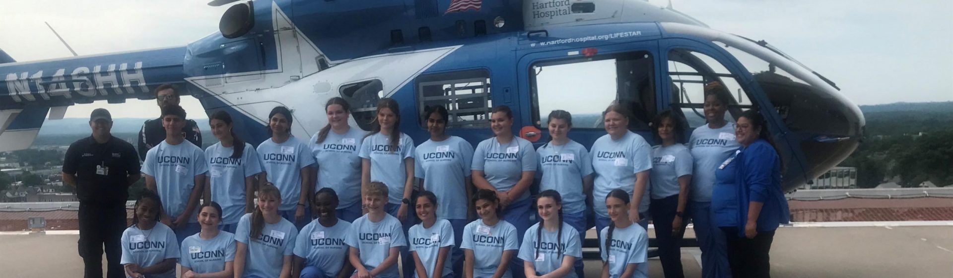 Students from the EINP program standing in front of a blue helicopter